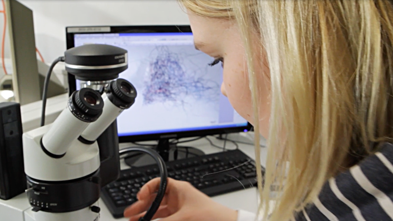 Peron die gerade etwas Mikroskopiert.