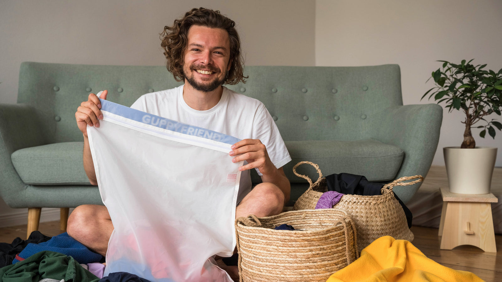 Person die überglücklich ihren Wäschebeutel von Guppyfriends mit Wäsche befüllt.